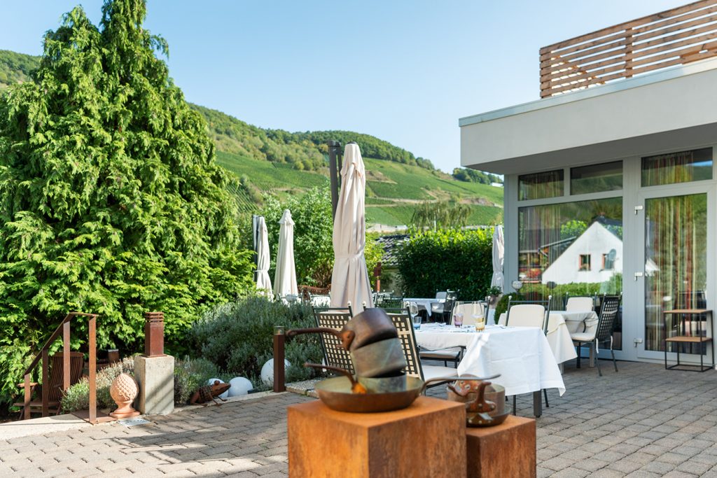 Tische auf der Terrasse des Wein- & Tafelhaus mit Blick auf die Weinberge